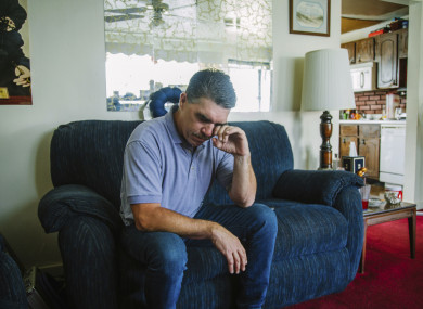 Robert Mizic, 47, watches the press conference at his home in Turtle Creek, Pa. Mizic says he was abused by his parish priest 35 years ago.