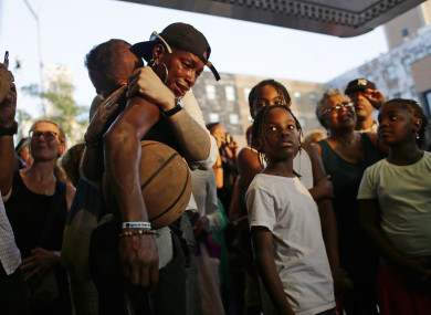 A woman is consoled at a makeshift memorial for the late singer.