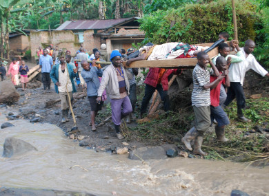 Residence carry an injured person in Bududa District, Uganda.