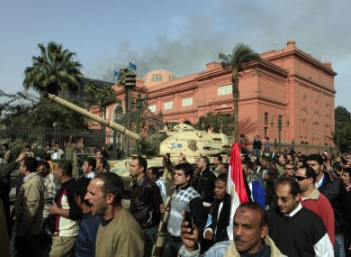 The Egyptian Museum in downtown Cairo is guarded by an army tank. The smoke seen behind is coming from the headquarters of President Mubarak's National Democratic Party.