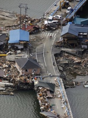 Debris from tsunami-stricken houses being removed from a bridge in Ishinomaki, Miyagi Prefecture, Japan, Tuesday, March 22.