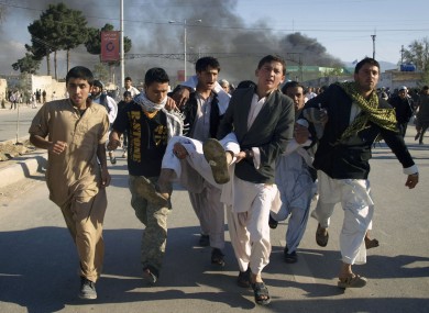 Afghans carry one of the injured UN staff to medical aid after this afternoon's protests. The injured man later died in hospital.