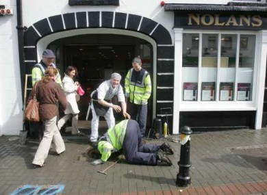Gardaí check manholes outside a butchers in Kilcullen, Co Kildare which the Queen will pass through on Thursday.