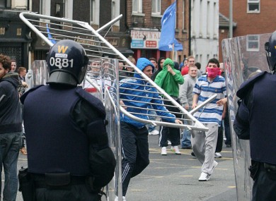 Protestors throw a barrier at Garda in a street in Dublin during skirmishes this afternoon, in which 21 people were arrested.