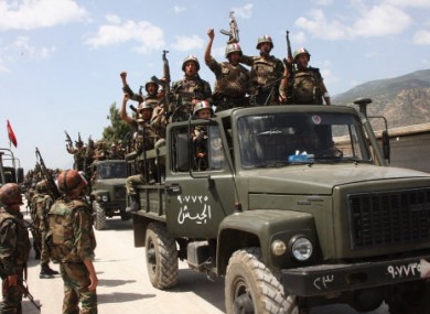 In this photo taken on Friday during a government-organised visit for media, Syrian soldiers cheer as they enter a village near Jisr al-Shughour.