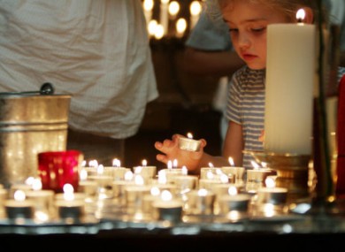 A child lights a candle after a special London prayer service for the two terrorist attacks in Norway.