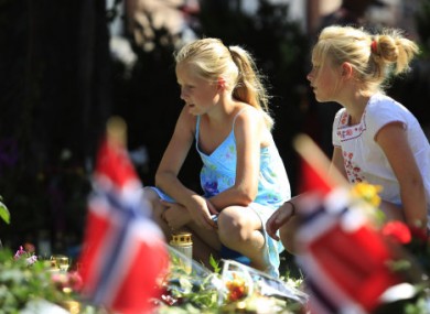 Oslo: Children sit by floral tributes left in memory of the victims of the 22 July bomb and gun attacks.