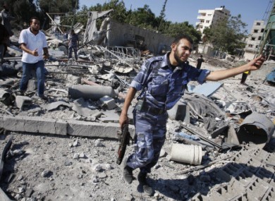 Hamas members check the damage to a Hamas training camp after an Israeli airstrike yesterday morning.