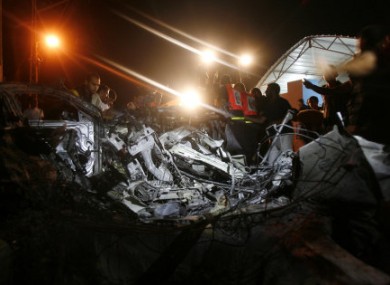 Palestinians look at the wreckage of a car after it was hit by an Israeli missile, killing an Islamic Jihad militant in Gaza.