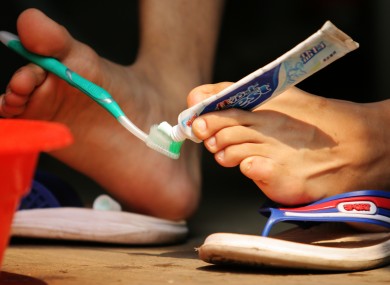 Wu Jianping, 22, who lost his arms in an accident when he was five, brushes his teeth.