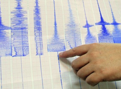File photo: a seismologist points at a Richter scale graph showing a 6.4-magnitude earthquake.