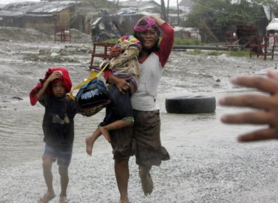 A family flees their home in Manila today during Typhoon Nesat.