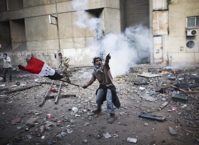 A protester points to incoming tear gas in Cairo today.
