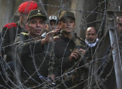 An Egyptian army officer tries to communicate with protesters across a barricade near Tahrir Sq, Cairo.
