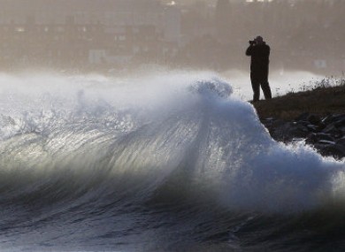 A man photographs waves at Dublin's Great South Wall today.