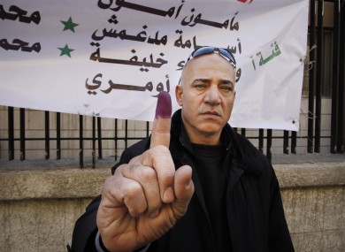 A man shows his inked finger after voting in Damascus today.