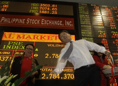 Philippine Stock Exchange director Alejandro Yu throws chocolate coins at the start of trading to mark the first trading day of 2012.