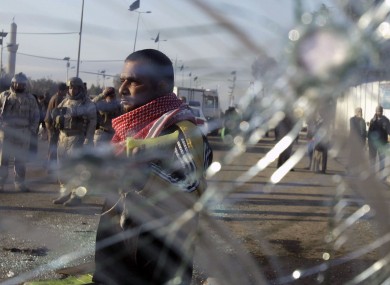Iraqi security forces and civilians seen through smashed glass after an explosion in Baghdad earlier this month.