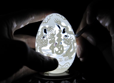 Wen Fuliang carves dragon images on an eggshell to welcome the Spring Festival on January 12, 2012 in Xi'an, Shaanxi Province of China.
