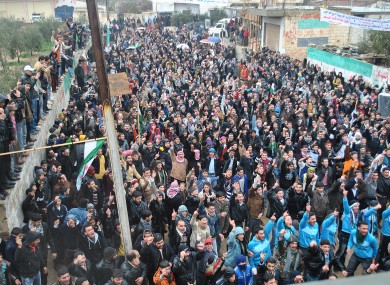 Anti-Syrian regime protesters raise their hands and chant slogans during a demonstration against Syrian President Bashar Assad in the Deir Baghlaba area in Homs province on Friday.