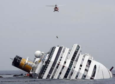 An Italian firefighter being lowered onto the Costa Concordia during the search.