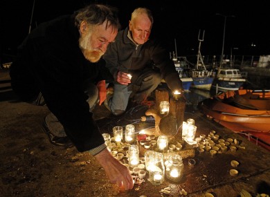 Candles are lit at a memorial on the pier at Union Hall.