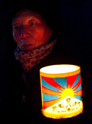 A Tibetan Buddhist man holds a lantern with the flag of Tibet during a protest in January 2012.