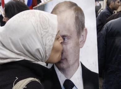 A Syrian woman kisses a poster of Russia's Vladimir Putin during a pro-Syrian government rally on 4 March.