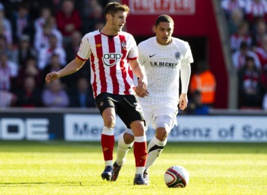 Adam Lallana of Southampton passes under pressure from Nathan Doyle of Barnsley.