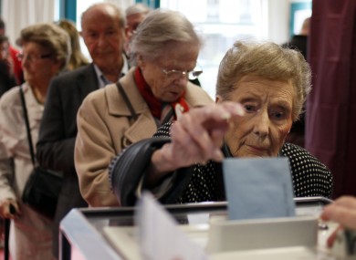A woman casts her ballot during the first round of the French elections in Lille, northern France, Sunday, April 22, 2012