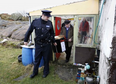 Garda Ronan McNamara and polling officer Hugh O'Donald carry the ballot box from the polling station on Innisfree Island in last year's general election.
