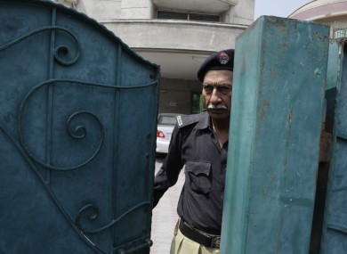 A Pakistani police officer looks out from the house of a kidnapped American development expert Warren Weinstein on Thursday, Aug 25, 2011 in Lahore, Pakistan