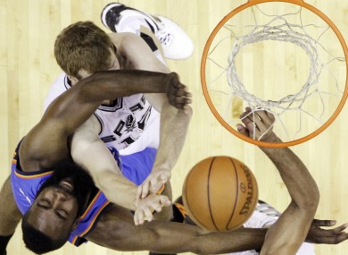 Oklahoma City Thunder guard James Harden (13) and San Antonio Spurs power forward Matt Bonner (15) fight for the ball under the basket.