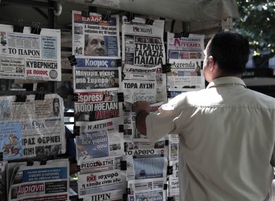 A man looks at the front pages of newspapers in Thessaloniki