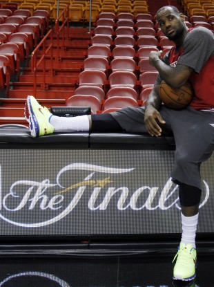 Miami Heat small forward LeBron James takes a break on the scorer's table during practice yesterday.