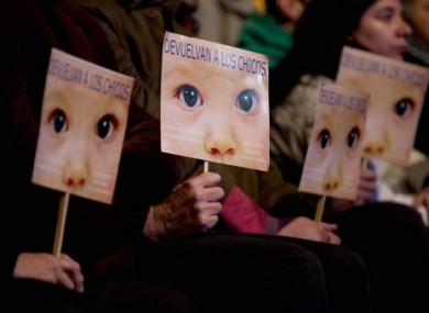 People hold signs that read in Spanish