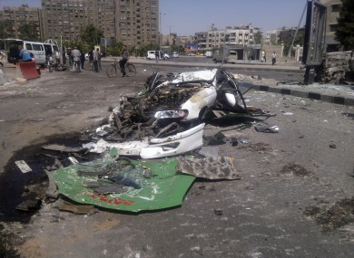 This citizen journalist image shows a destroyed car on a street damaged by tank treads after fighting between rebels and Syrian troops in the Yarmouk camp for Palestinian refugees in south Damascus yesterday.