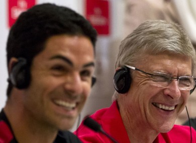 Arsene Wenger, right, and midfielder Mikel Arteta smile during a press conference in Beijing today.