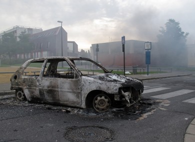The shell of a burnt out car is seen in a neighborhood of Amiens