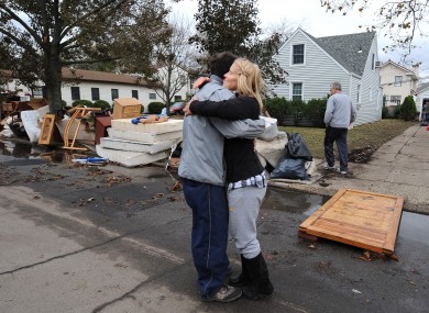 Beth Skudin, right, hugs a neighbor outside her home that was flooded by Superstorm Sandy, Thursday, Nov 1, 2012, in Long Beach, N.Y.