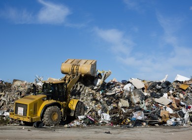A bulldozer pushes to the top of a debris mountain containing the remnants of homes damaged or destroyed by Superstorm Sandy.