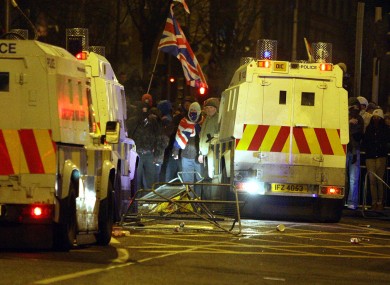 Loyalist protestors carrying Union flags clash with police outside the City Hall in Belfast on Monday.