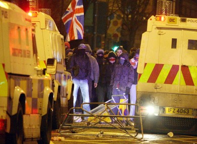 Loyalist protestors carrying Union flags clash with police outside the City Hall in Belfast on Monday evening.