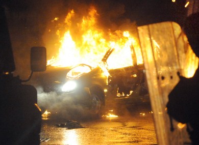 A burned out car during disturbances which erupted in east Belfast, with police coming under attack for a fourth night in a row.