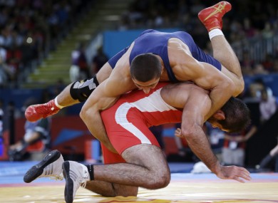 Kurban Kurbanov of Uzbekistan, in red, and George Gogshelidze of Georgia wrestle at London 2012.