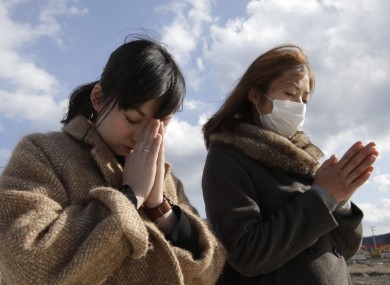 People offer prayers in front of the remains of a disaster control centre, in an area devastated by the March 11, 2011 earthquake and tsunami.