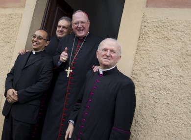 New York Archbishop Cardinal Timothy Dolan, second from right, poses for a photo as he leaves the Saint Mary of Guadalupe church after celebrating mass, in Rome, yesterday.