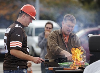 Cleveland Browns fan Kevin Vassar cooks some burgers on the grill.
