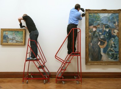 Art handlers hang Manet's Jour d'été and Renoir's Les Parapluies in the Hugh Lane Gallery in Dublin this week