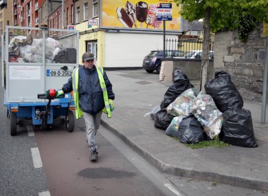 A Dublin City Council employee pictured near illegal rubbish.